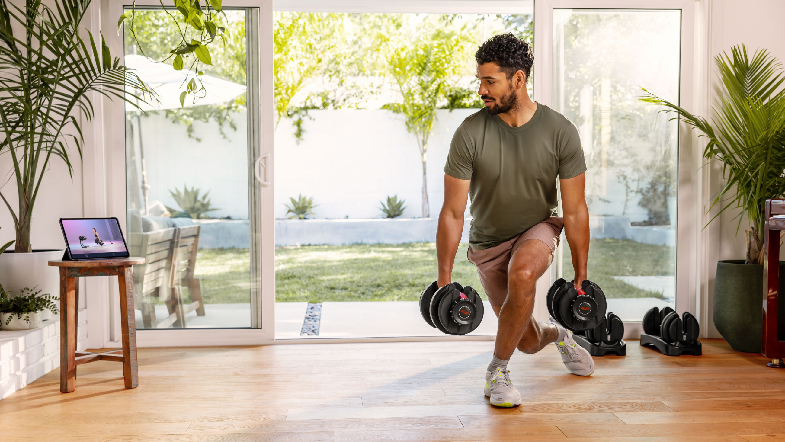 https://www.bowflex.com/dw/image/v2/AAYW_PRD/on/demandware.static/-/Sites-nautilus-master-catalog/default/dw7f105c74/images/bfx/weights/100131/552-dumbbell-curtsey-lunge-in-home-m-ll.jpg?sw=2600&sh=1464&sm=fit