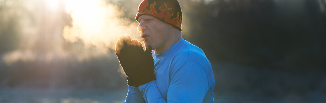 A man outdoors, in workout clothes looking cold.